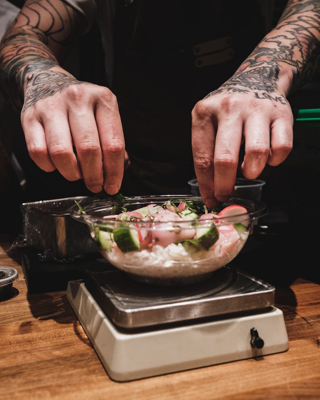 hands of a person over a glass of bowl on a weighing scale